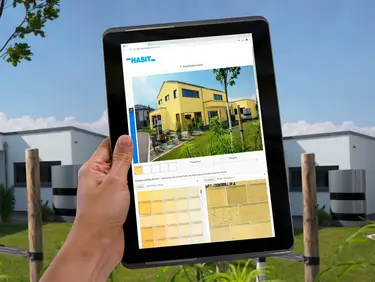 Im Hintergrund ein modernes Haus und im Vordergrund HASIT Fassadenkonfigurator am Tablet