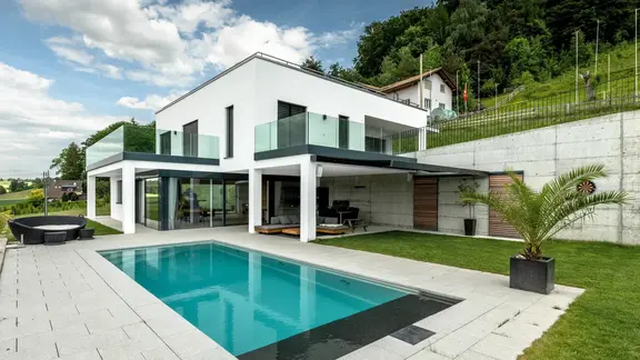 Maison individuelle moderne avec piscine et façade extérieure crépie en blanc avec système composite d'isolation thermique