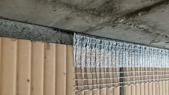 Bande de désolidarisation Stucanet® Easy Fix avec bande autocollante collée sur la maçonnerie, prête à être enduite