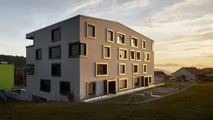 Mehrfamilienhaus mit moderner WDVS-Fassade im Sonnenuntergang