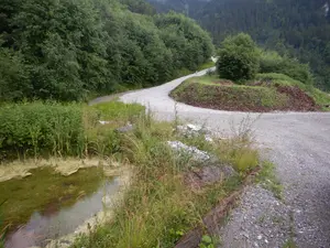 Renaturierter Bereich mit Tümpel und Schotterweg durch den stillgelegten Bereich des Steinbruchs in Ennetmoos