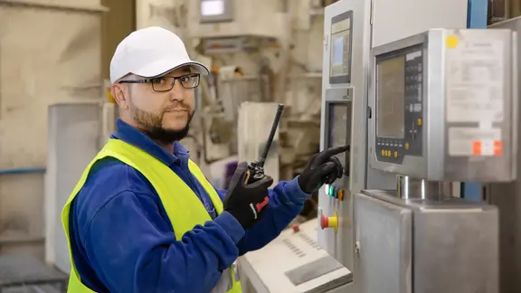 Werksmitarbeiter beim Bedienen einer Maschine