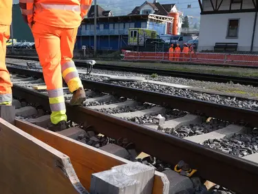 Gleisbereich am Bahnhof Schwyz mit Bauarbeitern und Fixit POR Silo im Hintergrund