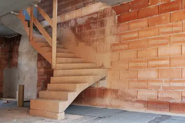 Innenraum einer Baustelle mit einer unverputzten Ziegelwand