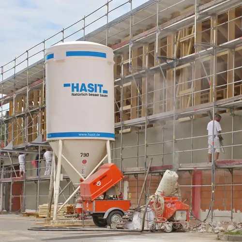 Ein Silo von HASIT steht auf einer Baustelle.