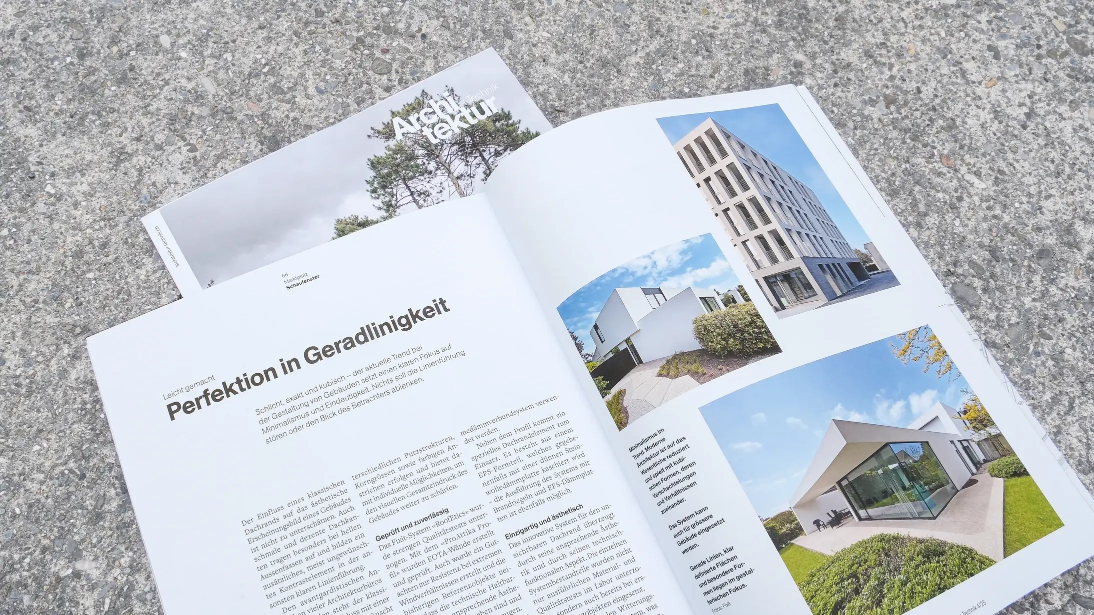 Le magazine Architektur+Technik, ouvert à la page du reportage sur Fixit RoofEtics®, est posé sur le sol en béton.