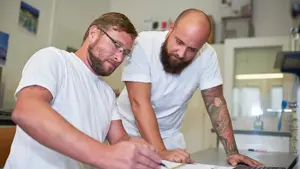 Zwei Mitarbeitende in der Entwicklungsabteilung prüfen einen Laborbericht