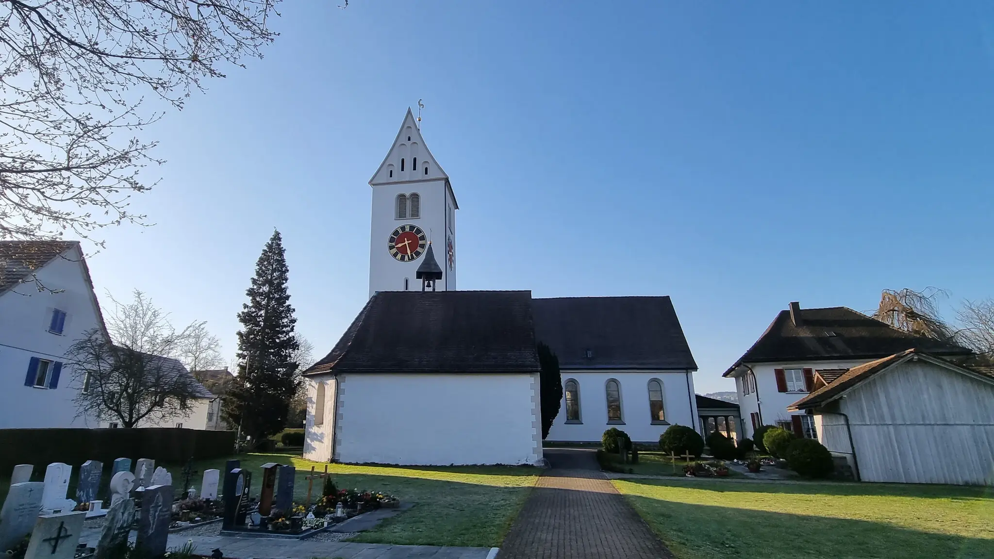 Gesamtansicht der Pfarrkirche in Wängi TG von Seiten des Friedhofs mit dem Kirchturm links
