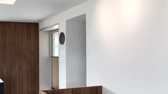 Intérieur moderne avec un beau crépi blanc sur les murs et le plafond contrastant avec le bois foncé