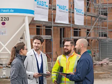 Ein Vertriebsmitarbeiter ist in einem Beratungsgespräch auf einer Baustelle