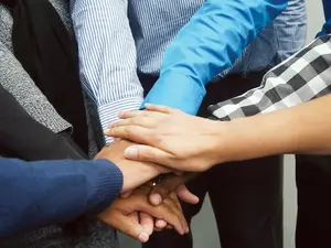 Hände sind zusammengelegt als Zeichen von Teamarbeit.