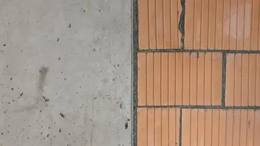 Un mur en béton à gauche et un mur en briques adjacent à droite