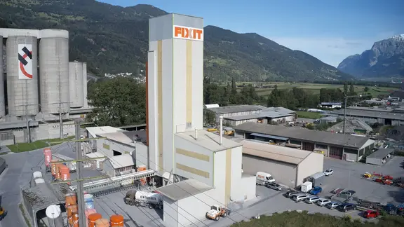 Luftaufnahme vom Produktionswerk der Fixit AG in Untervaz mit Produktionsturm, Silos und Lagerhalle