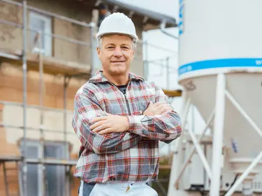 Ein Arbeiter steht vor einem Silo.