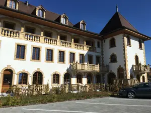 Maison de retraite médicalisée de Gampelen, crépie en blanc, avec une tour carrée et des éléments en grès sur les arêtes et les fenêtres.