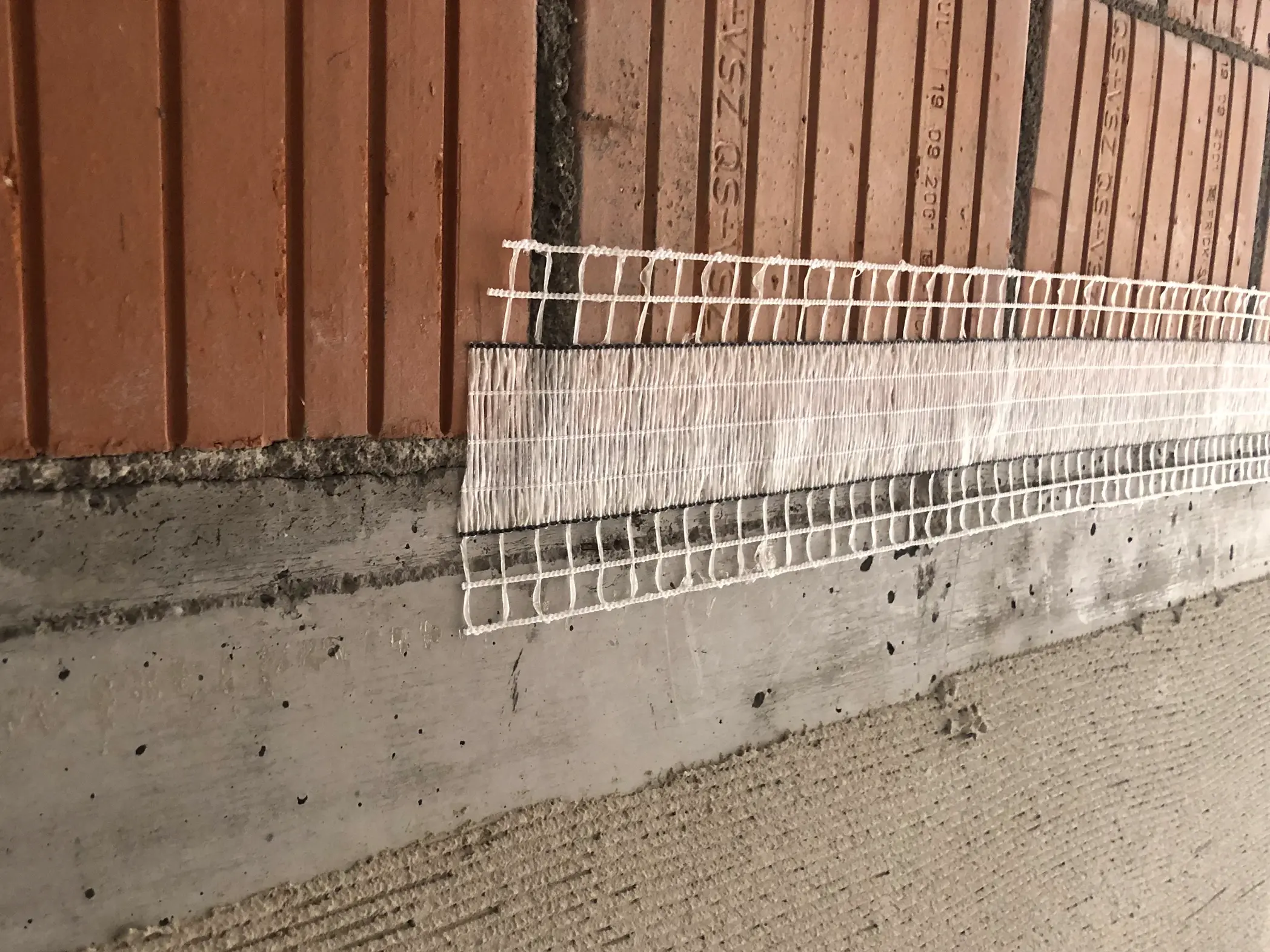 Stucanet® Easy Fix Bande de découplage sur une transition de matériaux entre béton et maçonnerie